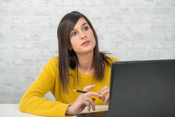 Junge nachdenkliche brünette Frau im Büro — Stockfoto