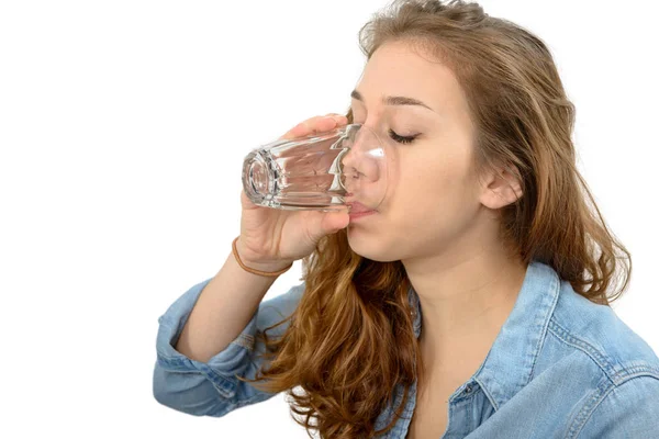 Junge Frau trinkt ein Glas Wasser, auf weiß — Stockfoto