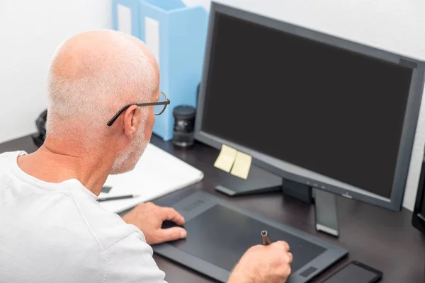 Volwassen man aan het werk op zijn grafisch tablet — Stockfoto