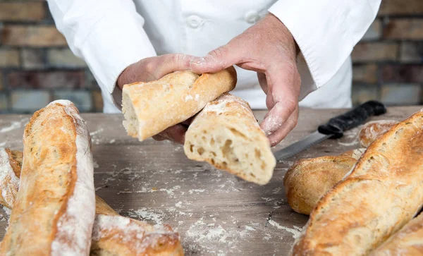 Baker cutting traditional bread french baguettes — Stock Photo, Image