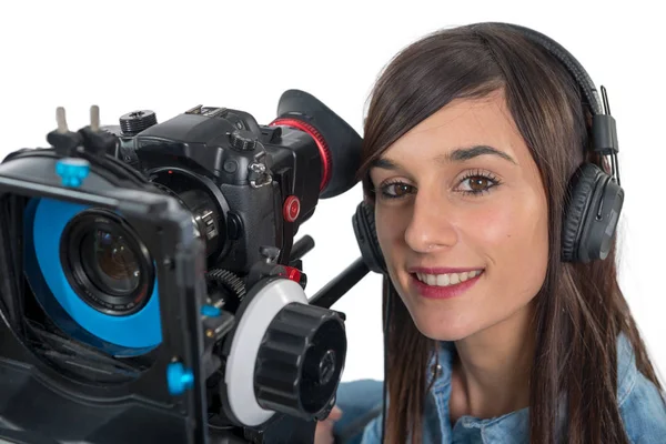 Beautiful young woman with SLR video camera and headphones — Stock Photo, Image