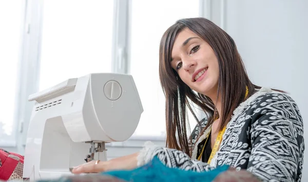 Fröhliche junge Näherin mit ihrer Nähmaschine — Stockfoto