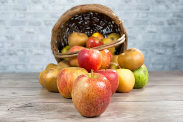 Korb mit Äpfeln auf dem Tisch verschüttet — Stockfoto