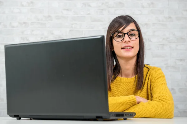 Portret van een jonge brunette zakenvrouw met haar laptop — Stockfoto