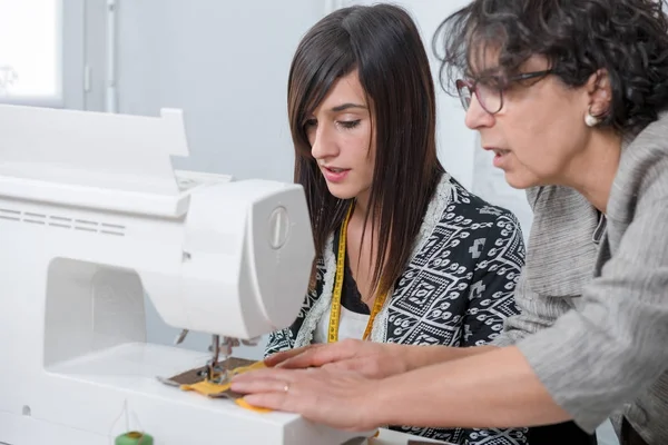 Seamstress and her apprentice with sewing machine — Stock Photo, Image