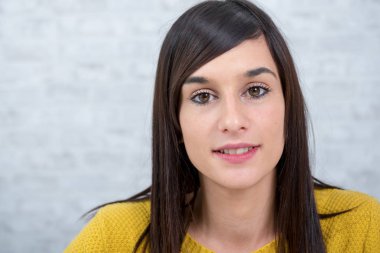 genç esmer ve gülümseyen kadın sarı giyinmiş