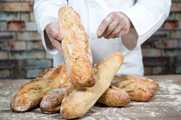 Baker with traditional bread french baguettes — Stock Photo, Image