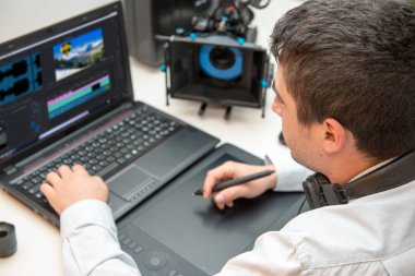 genç adam Tasarımcısı grafik tablet video düzenleme için kullanma