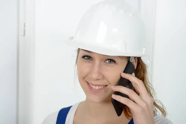 Ung ingenjör kvinna med säkerhet hård hatt prata telefon — Stockfoto