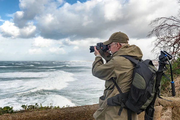 Homem fotógrafo trabalhando durante uma tempestade em Biarritz França — Fotografia de Stock