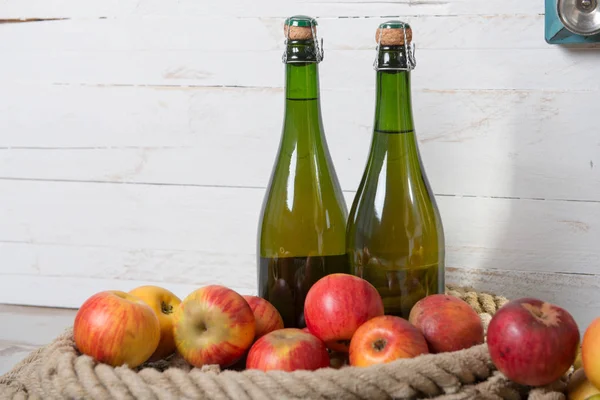 Dos botellas de sidra y manzanas rojas — Foto de Stock