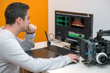 genç adam Tasarımcısı grafik tablet video düzenleme için kullanma