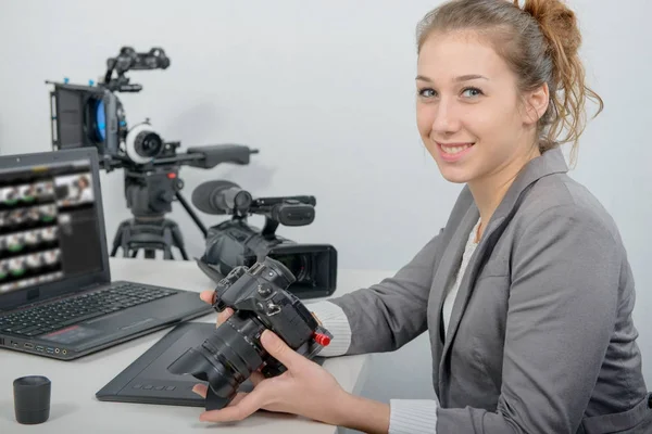 Pretty young woman photographer with camera in office — Stock Photo, Image