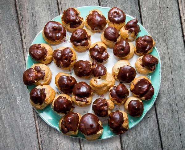 Chocolate covered vanilla cream pastry puffs closeup. — Stock Photo, Image