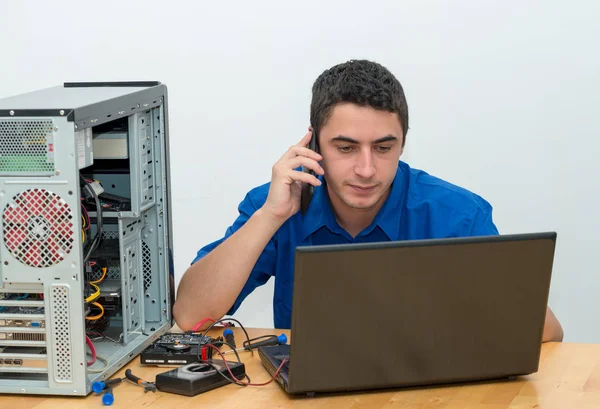 Jeune homme technicien travaillant sur ordinateur cassé et appeler le cus — Photo