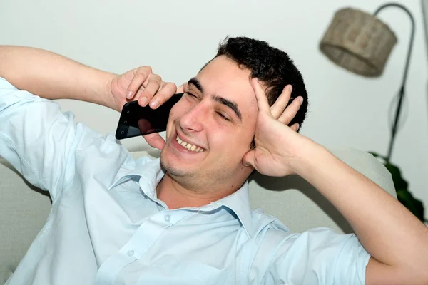 Boldog fiatalember mobiltelefonján hívja — Stock Fotó