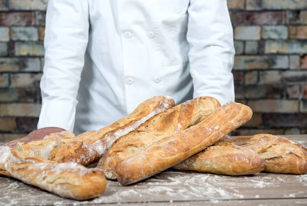 Baker with traditional bread french baguettes — Stock Photo, Image