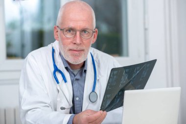Olgun Doktor Röntgen bir ofiste bakarak 