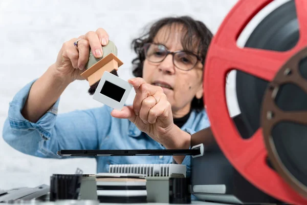 Woman technician cleaning a vintage slide — Stock Photo, Image