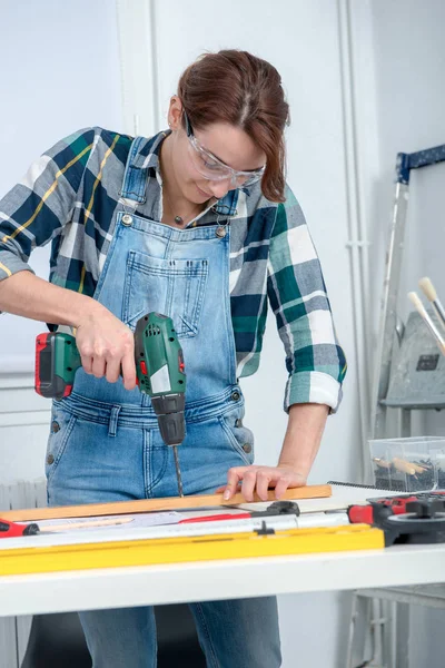 Pretty young smiling woman using cordless drill — Stock Photo, Image