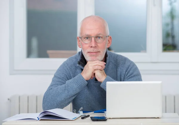 Hombre de mediana edad utilizando el ordenador portátil en su oficina —  Fotos de Stock