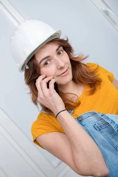 Ung ingenjör kvinna med säkerhet hård hatt prata telefon — Stockfoto