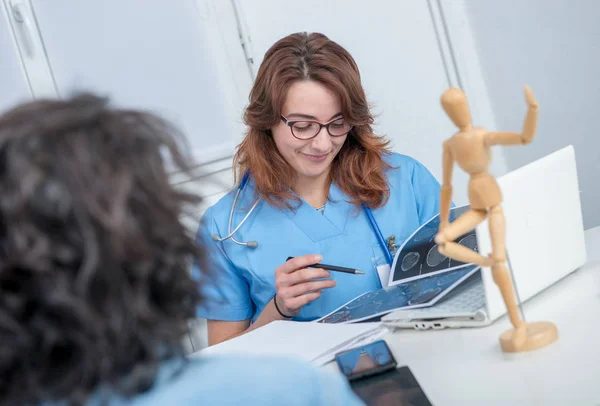 Young female doctor in the office with her patient — Stock Photo, Image