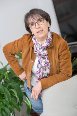 kahverengi ceket ve gözlük ile büyüleyici Olgun kadın