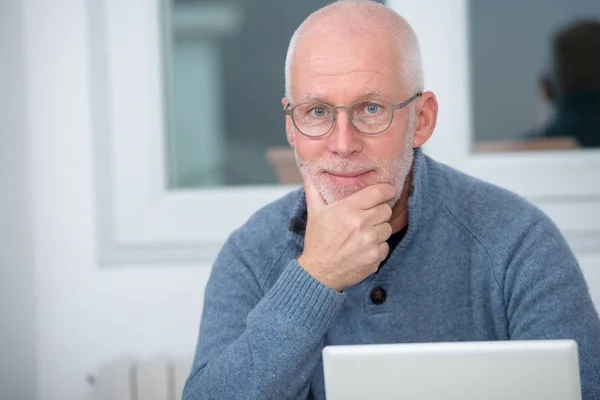 Μεσήλικας άνδρας που χρησιμοποιούν φορητό υπολογιστή στο γραφείο του — Φωτογραφία Αρχείου