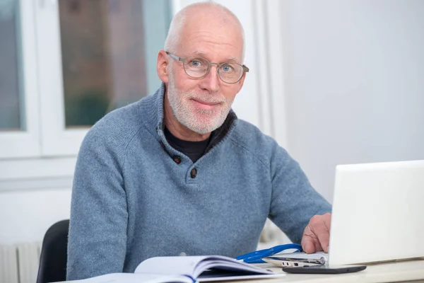 Homme d'âge moyen en utilisant un ordinateur portable dans son bureau — Photo