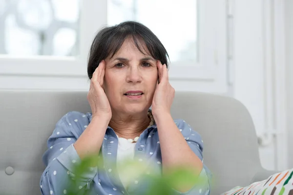 Zralá bruneta žena s bolestí hlavy doma — Stock fotografie
