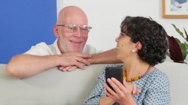 bir smartphone kullanarak ve gülümseyen kıdemli Çift