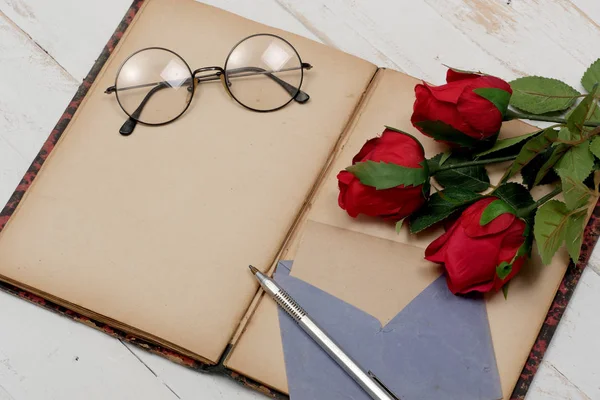 Concepto romántico, viejo cuaderno, rosas y vasos — Foto de Stock