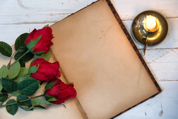 Concepto romántico, viejo cuaderno, rosas y vela pequeña — Foto de Stock