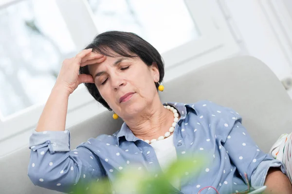 Zralá bruneta žena s bolestí hlavy doma — Stock fotografie