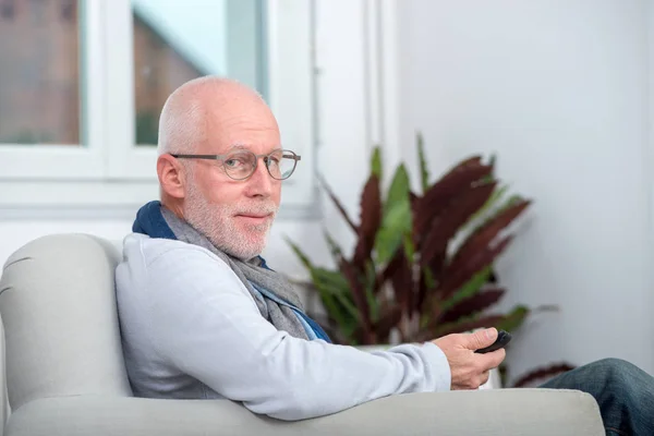 Hombre mayor guapo usando el teléfono en el sofá —  Fotos de Stock