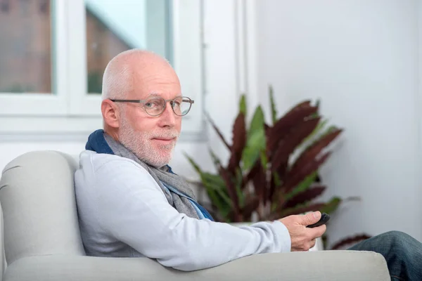 Beau sénior utilisant le téléphone sur le canapé — Photo