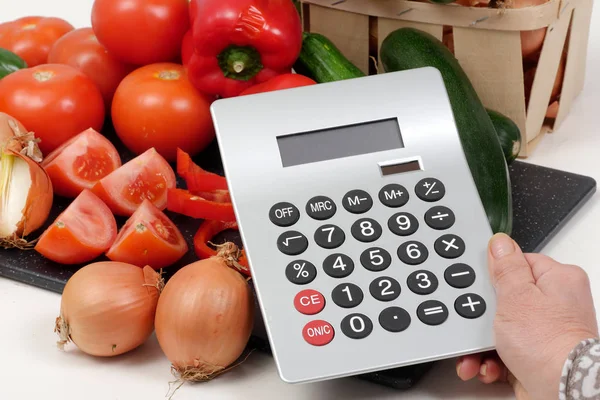 Legumes com uma calculadora na tabela branca — Fotografia de Stock