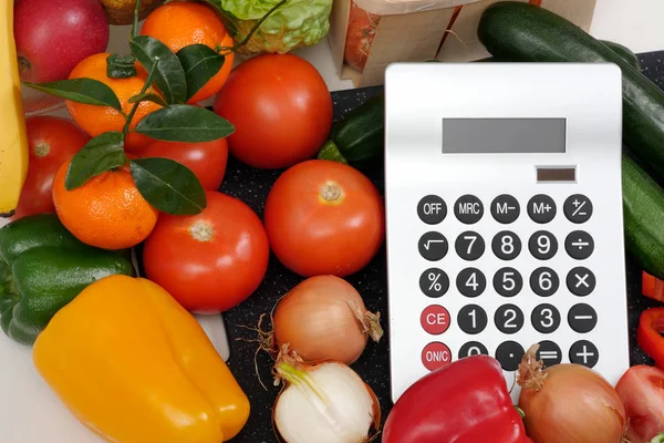 Zelenina s kalkulačkou na bílém stole — Stock fotografie