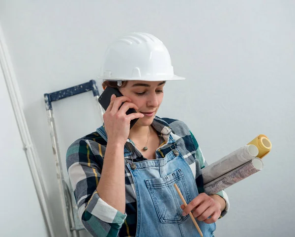 Mladý inženýr žena s bezpečnostní přilbou mluví o telefonu — Stock fotografie