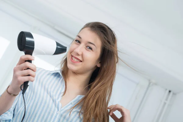 Pretty young woman is drying her hair — Stock Photo, Image