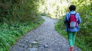 bir patika, arkadan görünüm yürüyen bir kadın