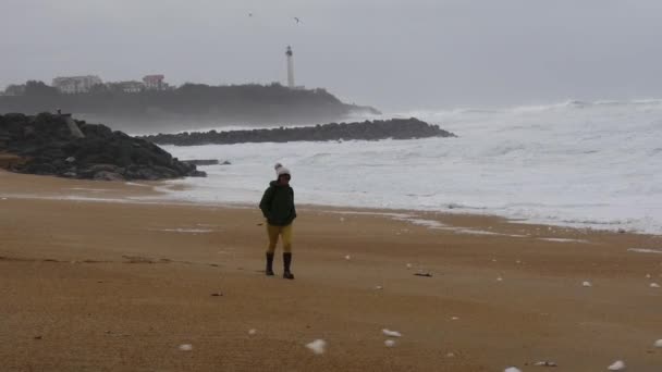法国比亚里茨的一场暴风雨中漫步在海滩上的女人 — 图库视频影像
