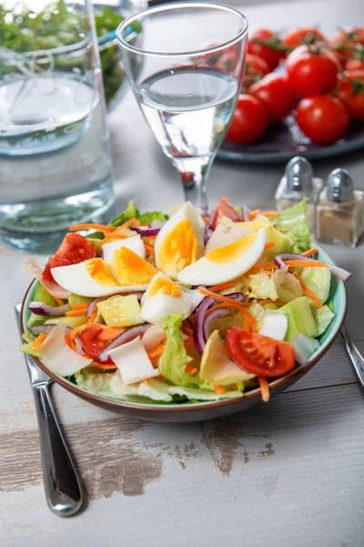 Salade de légumes sur table en bois blanc — Photo