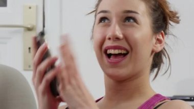 Kanepede bir akıllı telefon kullanan genç ve güzel kadın