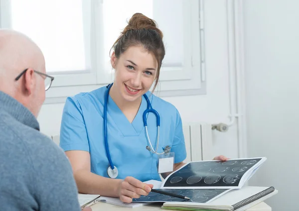 Young female doctor in the office with her patient — Stock Photo, Image