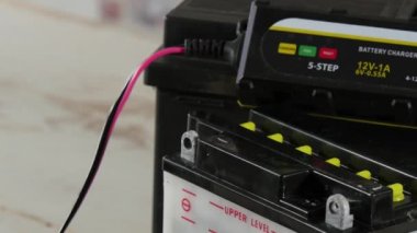 Kırmızı ve siyah jumper kabloları ile motosiklet pilin şarj edilmesi