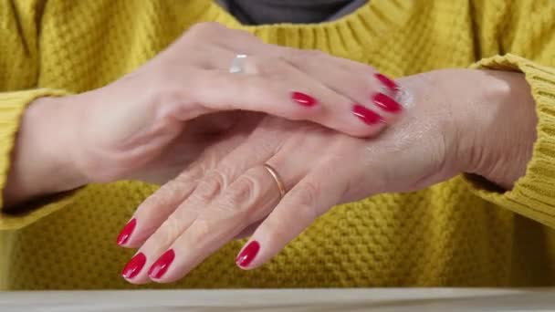 Senior Vrouw Haar Hand Met Een Witte Crème Wrijven — Stockvideo