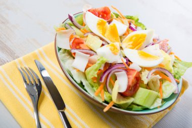 Sarı havlu üzerinde sebze salatası tabak