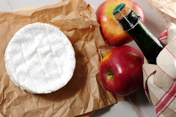 Camembert aus der Normandie mit Äpfeln und einer Flasche Cider — Stockfoto